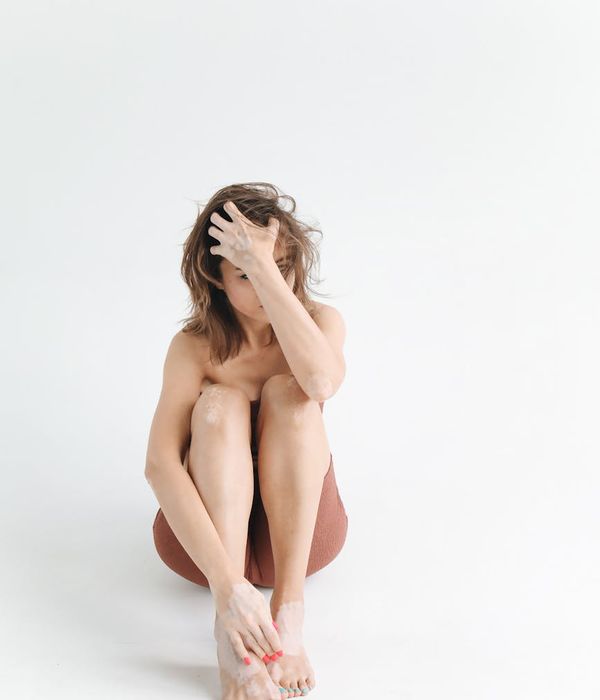 Woman in a calm yoga pose in a studio with soft, natural light.